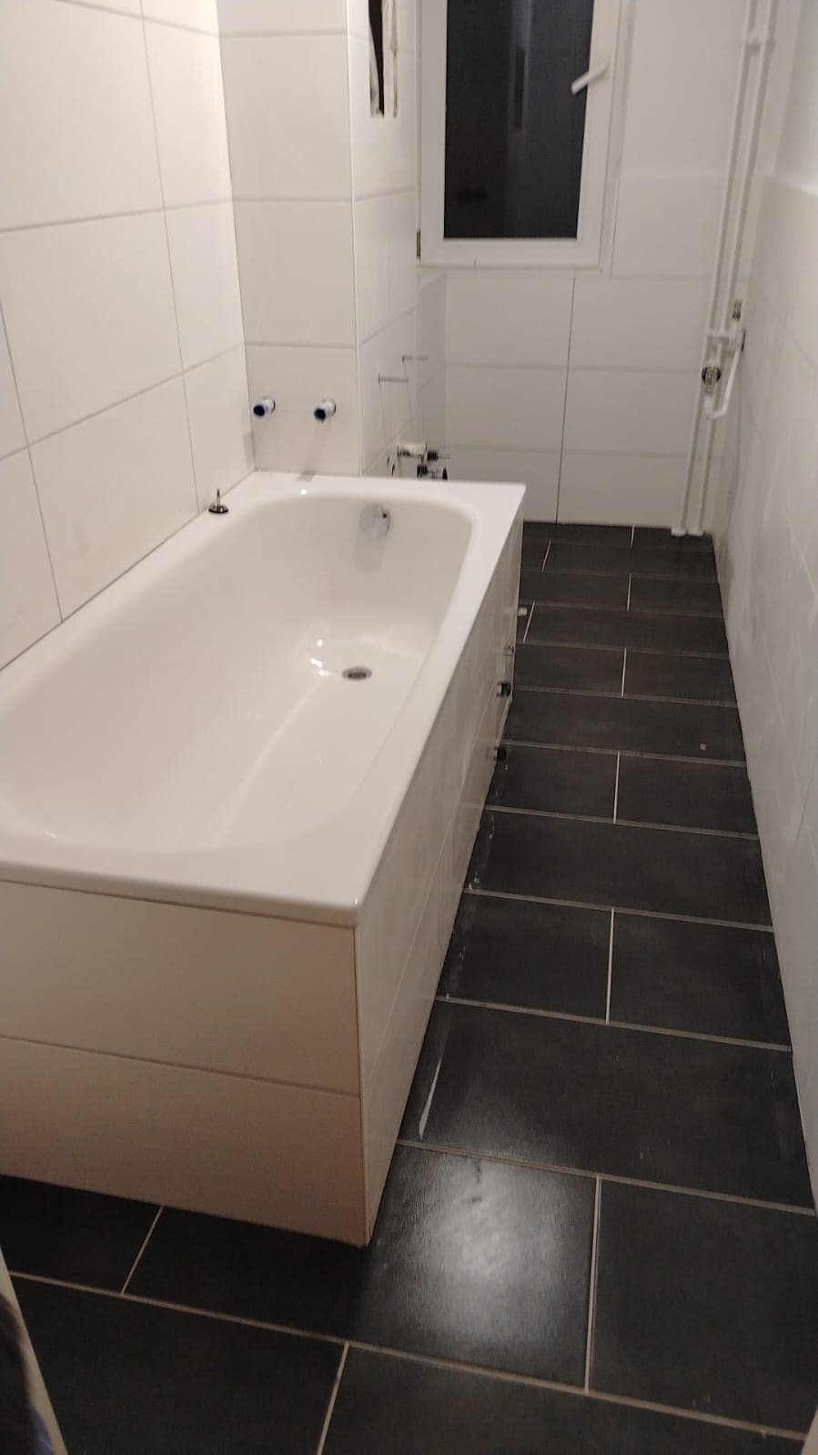 Wannenbad mit dunklem Fliesenboden — Bäder, NRW · Deutschland · Trust NordBau